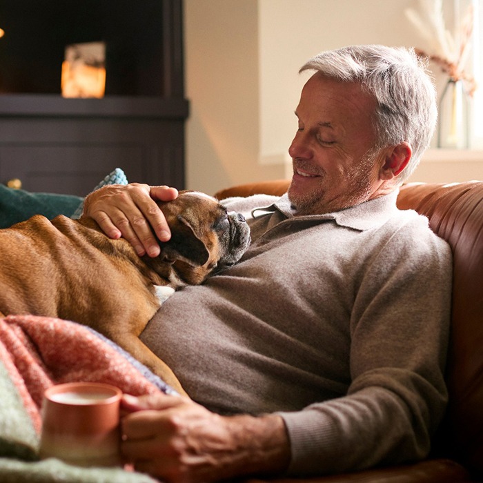 Man relaxing at home and petting his dog