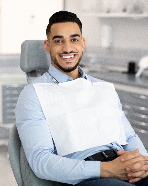 Man smiling while sitting in treatment chair